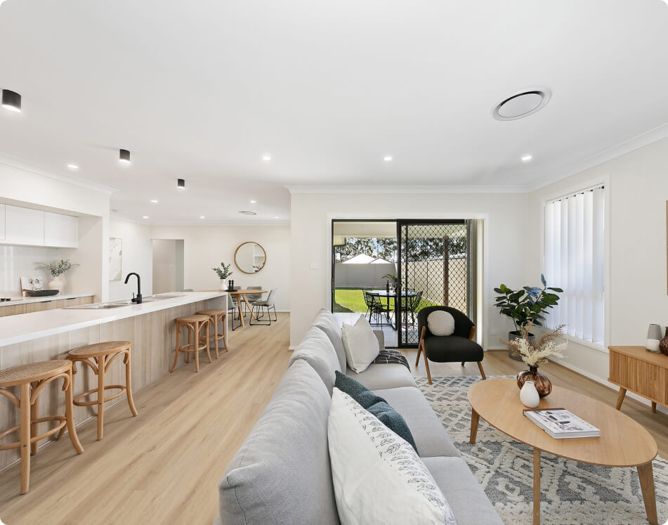 Bright open-plan living area with kitchen and sliding doors to backyard