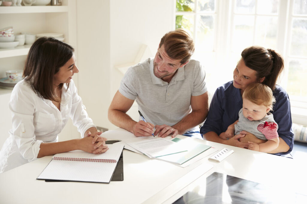 Family With Baby Meeting Financial Advisor At Home