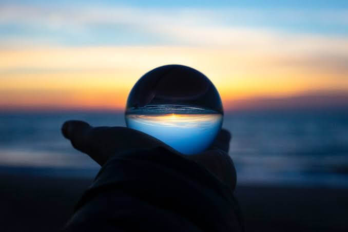 Crystal ball in hand at sunset